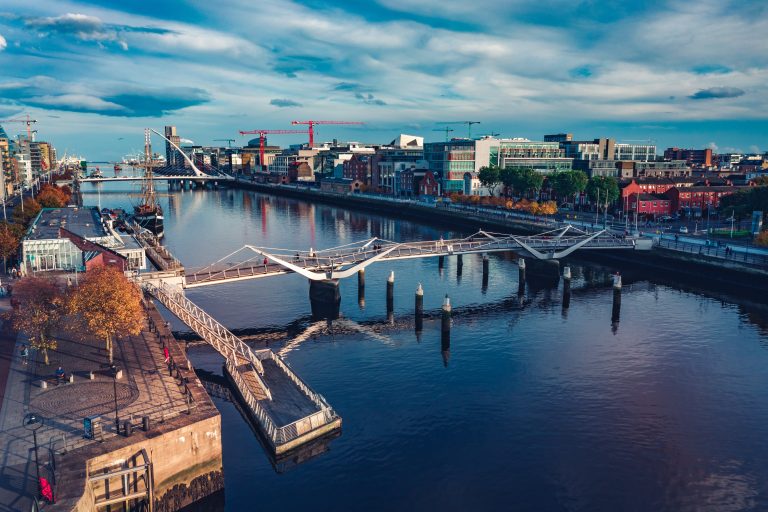 Modern office in Dublin Grand Canal Dock with analytical data screens illustrating Irish enterprise AI adoption statistics 2026.